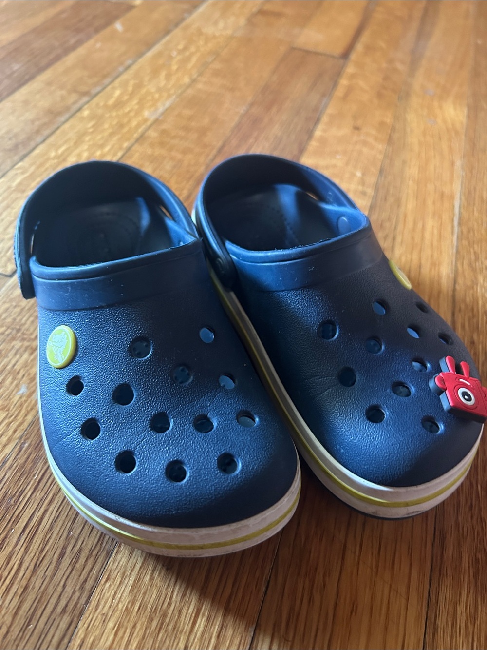 CROCS Kids Navy Clogs with Yellow Trim and Red Charm